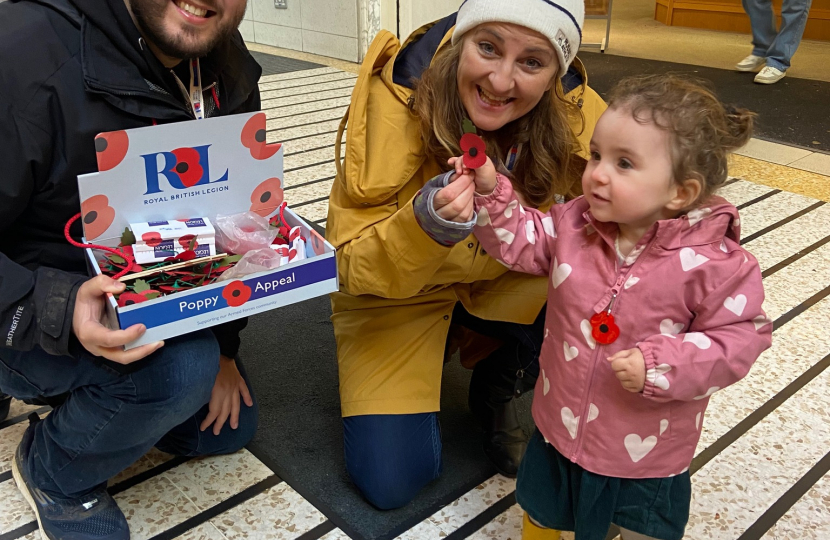 Caroline and Nicholas Taylor ensuring a little girl got her very first Poppy. All three pictured, smiling.